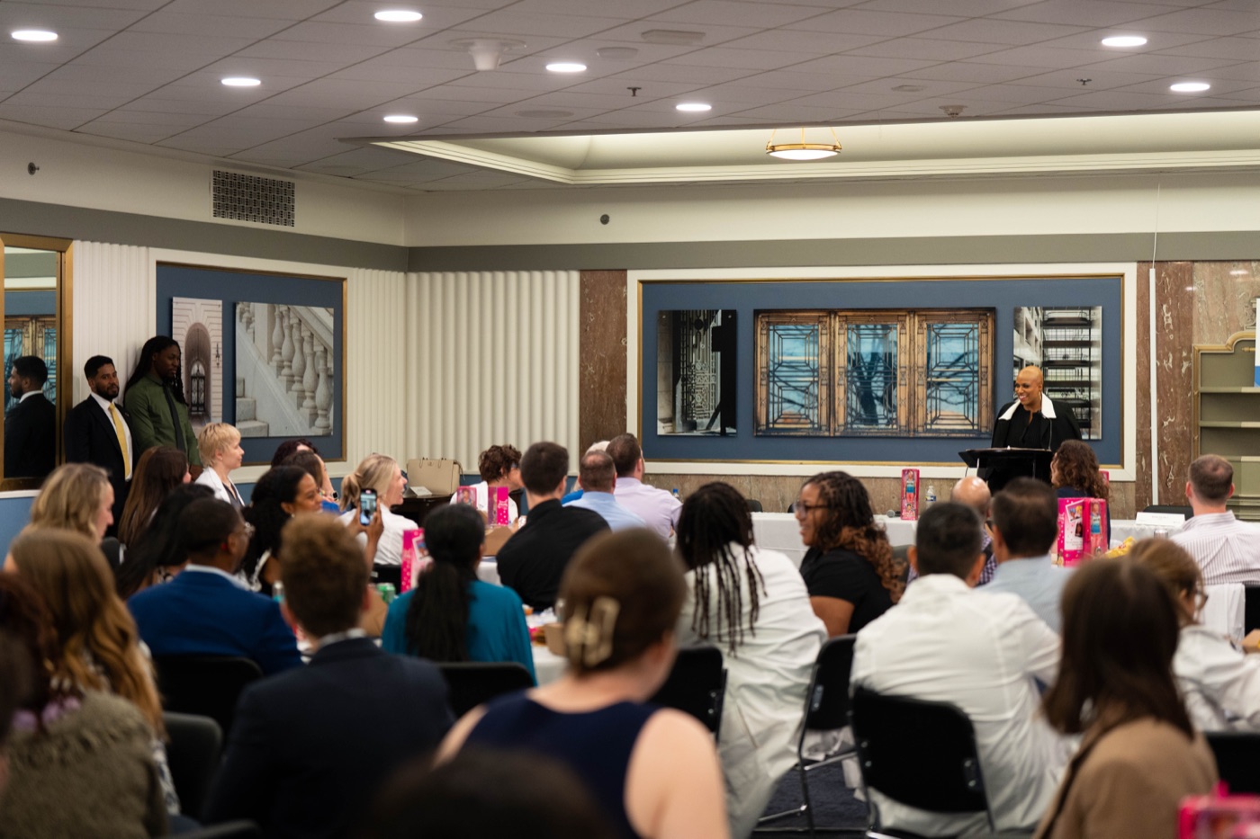 An audience listening to a speaker at a lectern